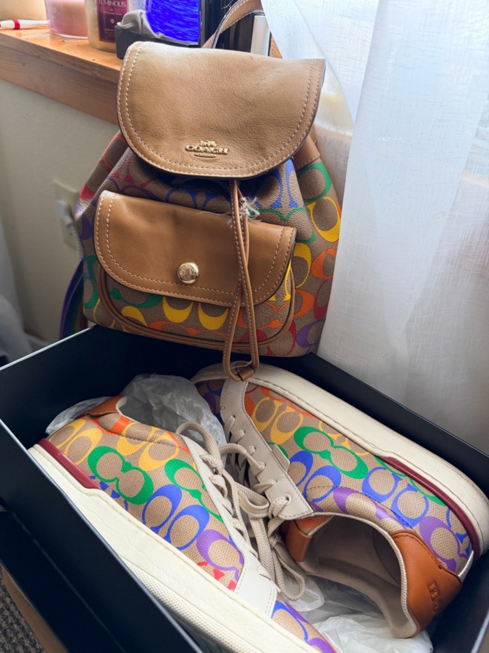 Coach Multicolor Signature Canvas Mini Backpack with matching sneakers.